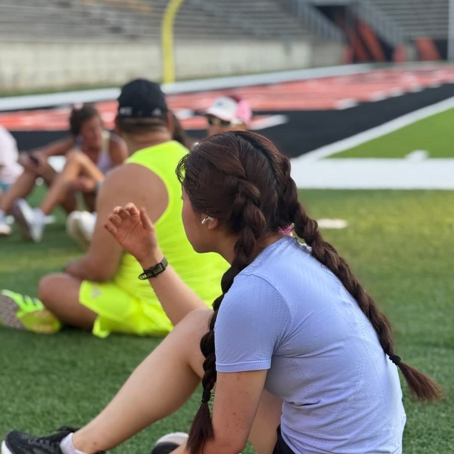 Runner resting on the turf after a group workout